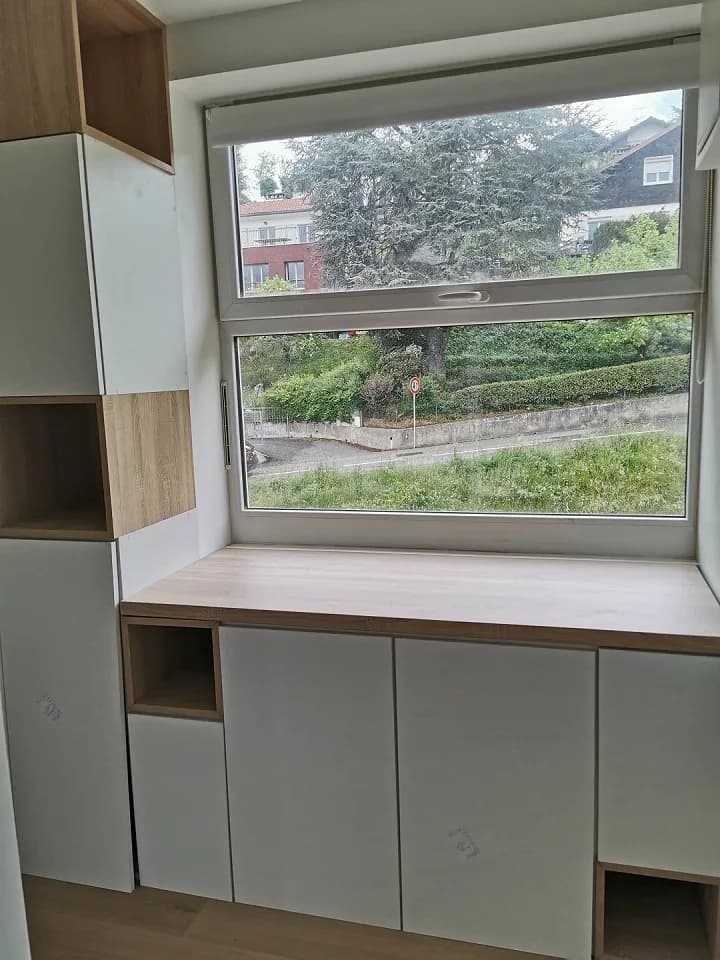 Rangements sur mesure et plan de travail bois installés sous la fenêtre